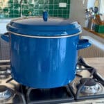 Blauer Einkochtopf mit Deckel während des Einkochvorgangs