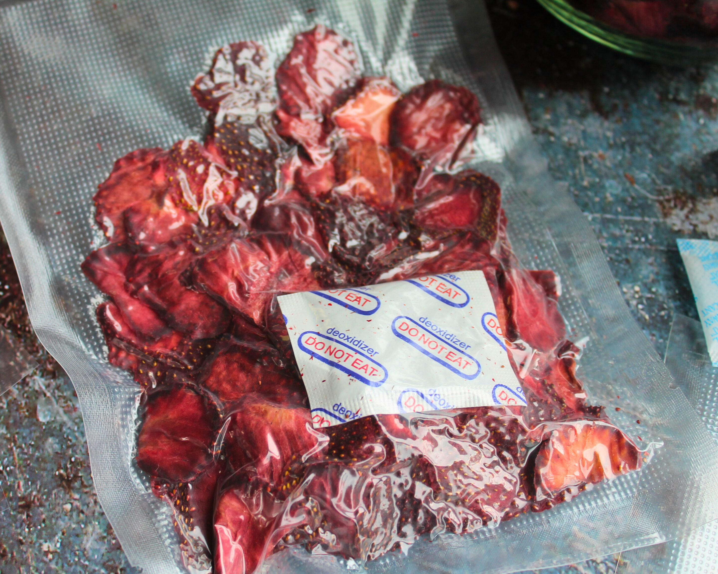 getrocknete-erdbeeren-vakuumiert-mit-absorber.jpg Getrocknete Erdbeerscheiben in Vakuumbeutel mit Sauerstoffabsorber – sicher gegen Schimmel und Botulismus gelagert.