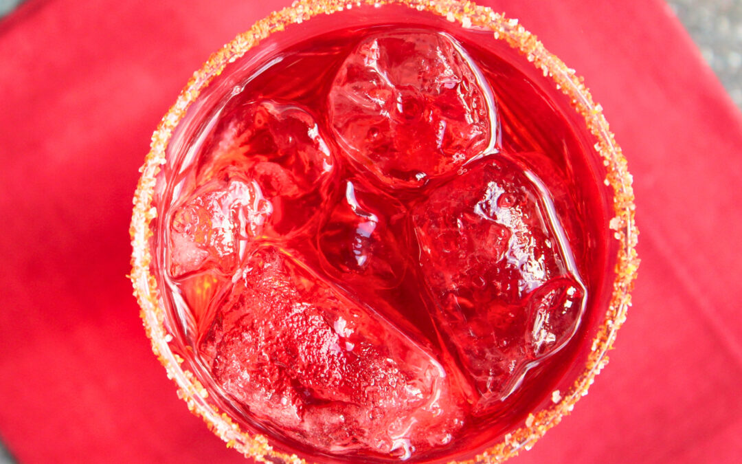 Roter Drink mit Tomatenzucker am Glasrand – kreative Verwendung von Tomatenhaut