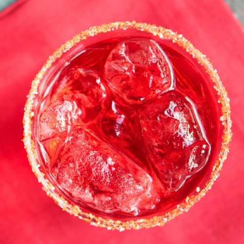 Roter Drink mit Tomatenzucker am Glasrand – kreative Verwendung von Tomatenhaut