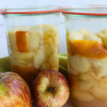 Zwei Gläser mit hellen, eingekochten Apfelscheiben – Basisrezept für Apfelvorrat und Apple Pie Filling nach USDA-Richtlinien.