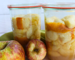 Zwei Gläser mit hellen, eingekochten Apfelscheiben – Basisrezept für Apfelvorrat und Apple Pie Filling nach USDA-Richtlinien.