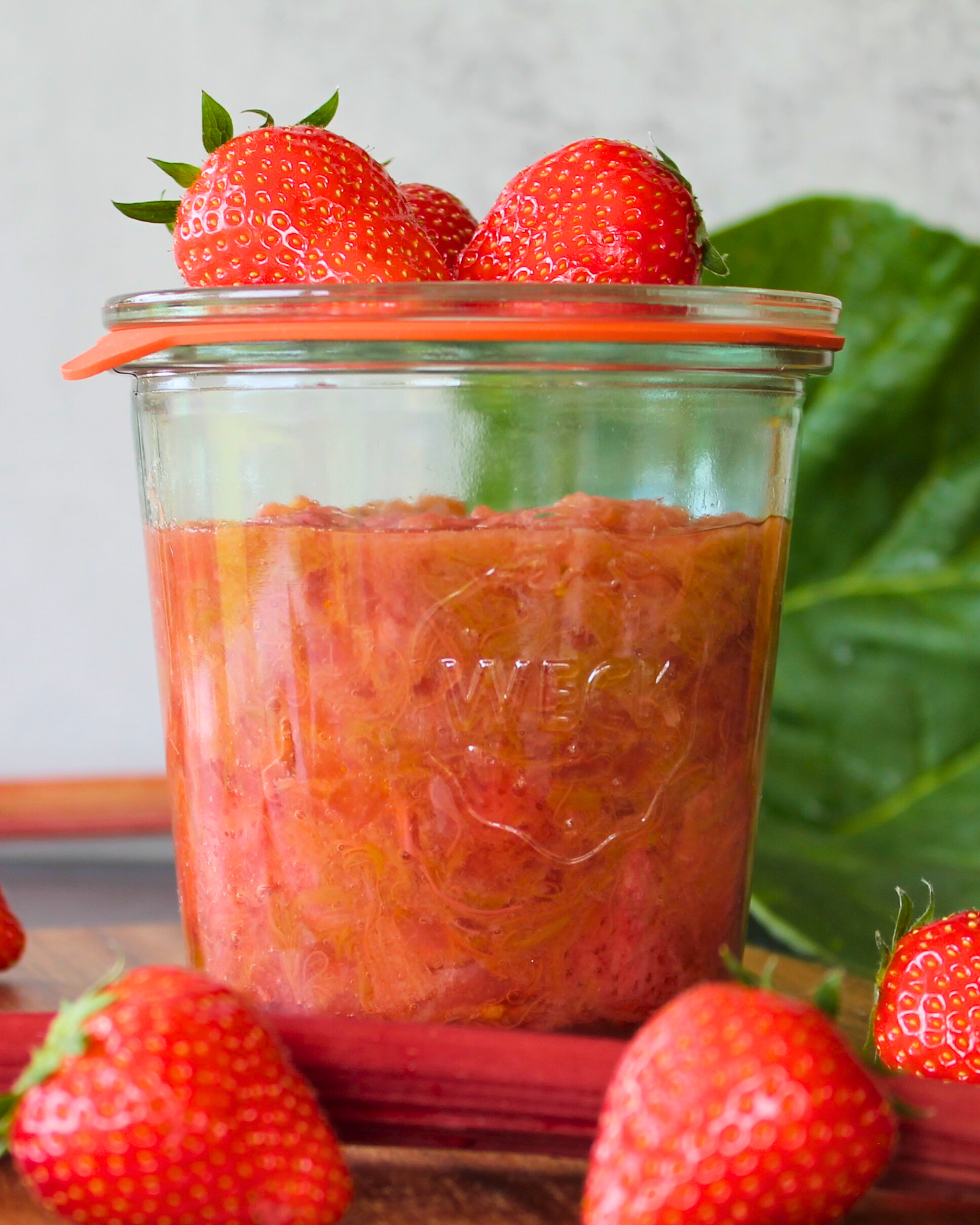 Selbstgemachtes Erdbeer-Rhabarber-Kuchenfuellung im Weckglas mit frischen Erdbeeren – fruchtiges Geschenk aus der Vorratskammer.