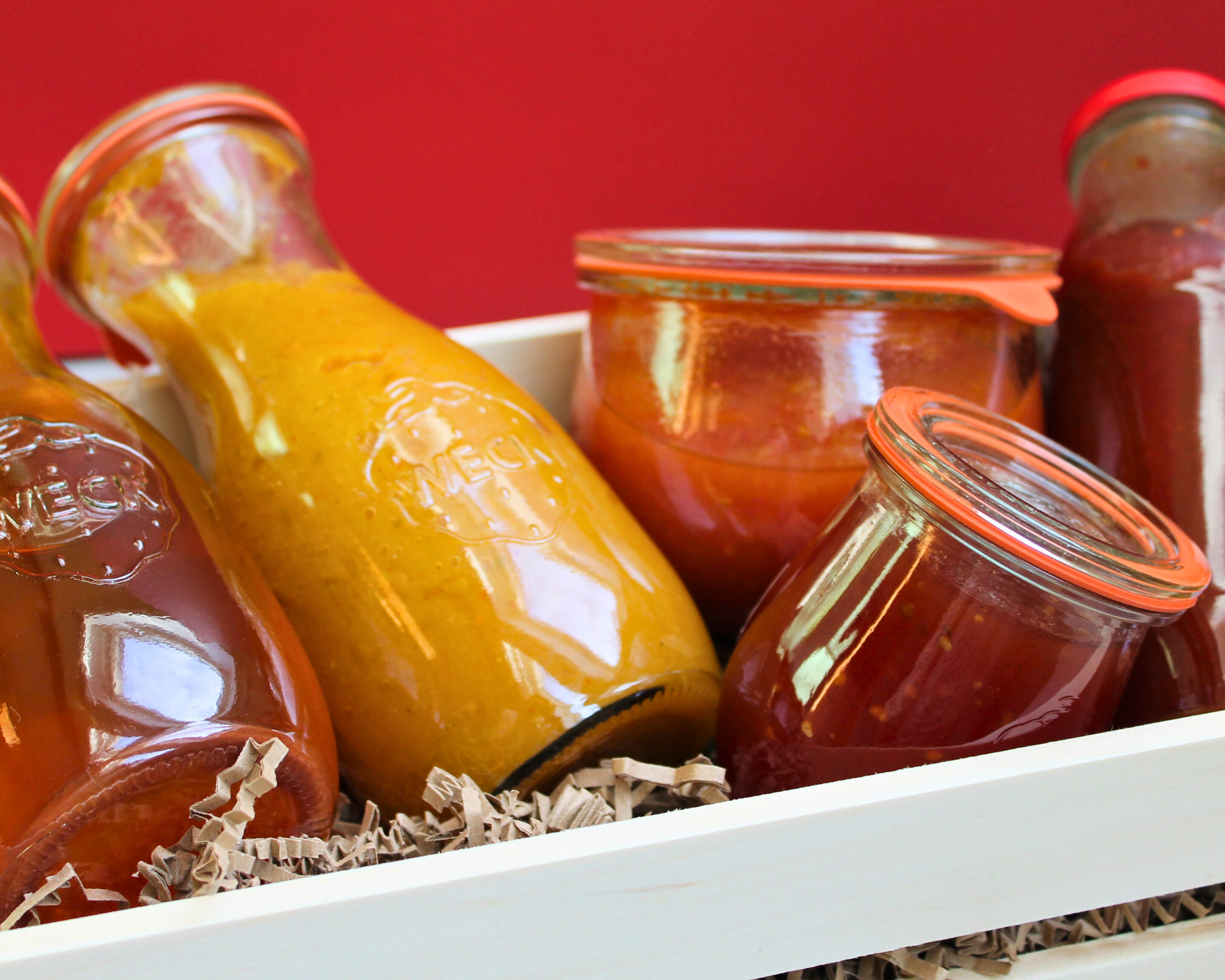 Eingekochte Saucen und Tomaten in Weckflaschen und Gläsern als weihnachtliches Geschenk aus dem Vorrat.