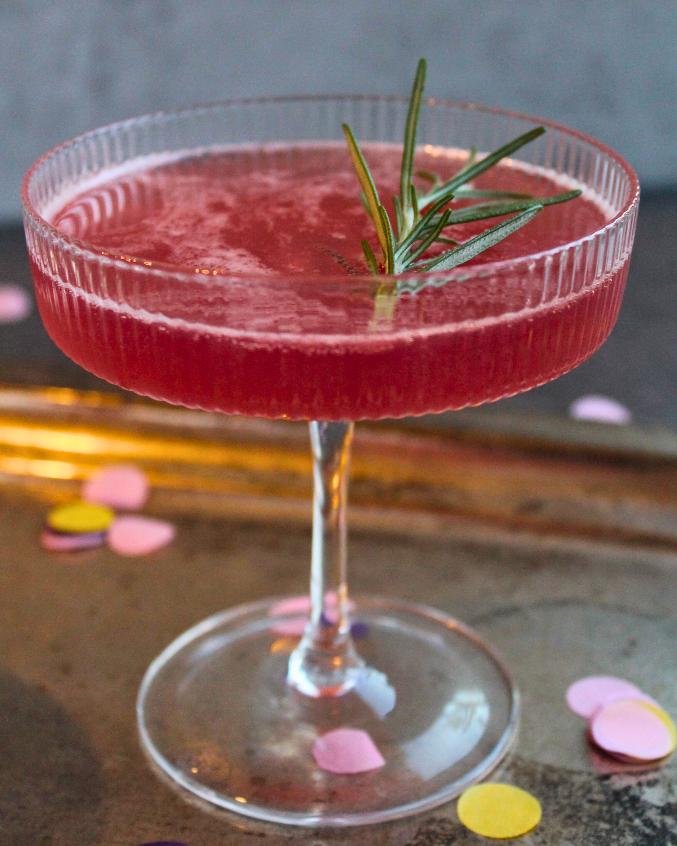 Winter-Berry Fizz mit Rosmarin in einer Sektschale, Cocktail aus Beerenmarmelade und Sekt