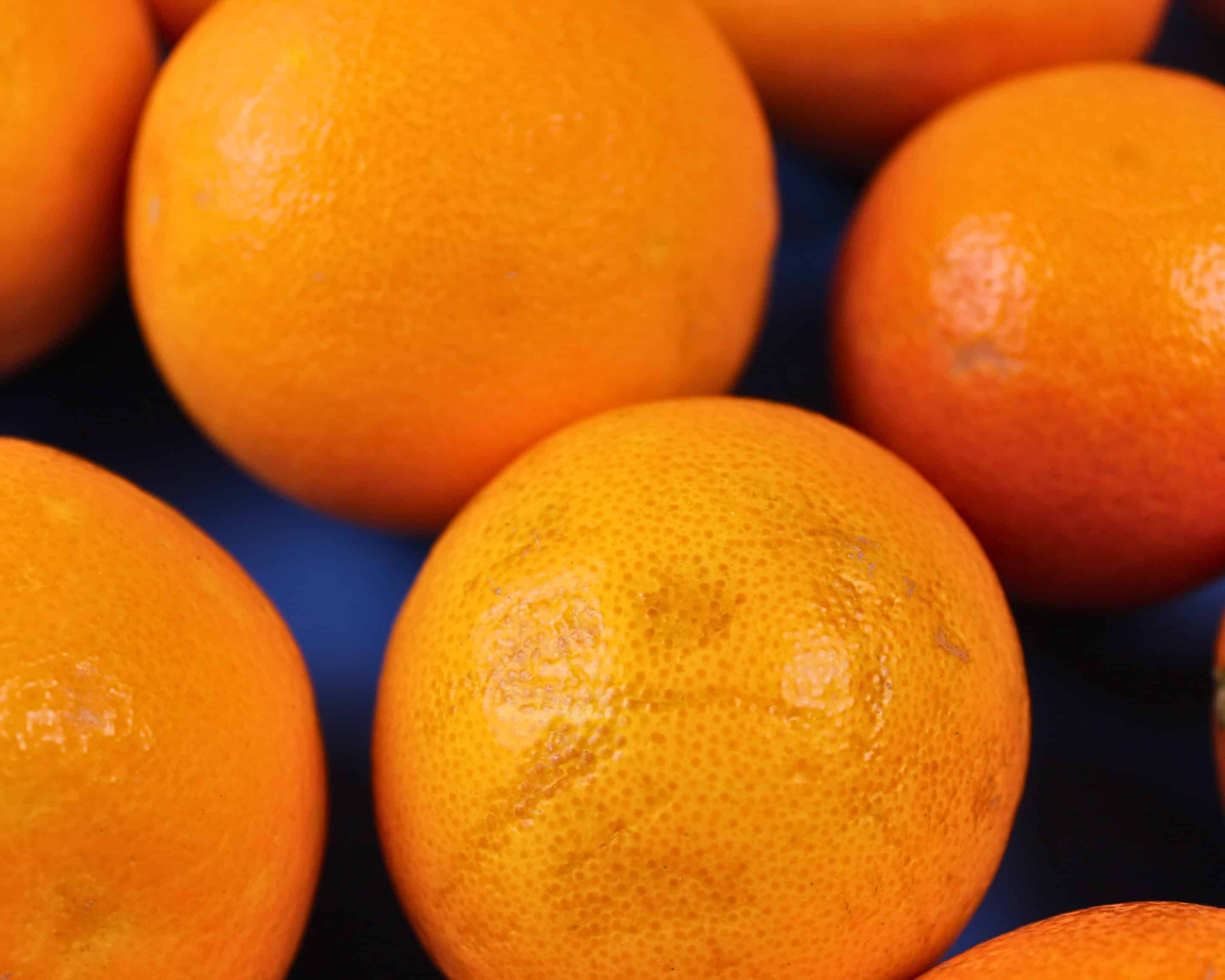 Nahaufnahme von frischen Orangen mit Schale als Grundlage für hausgemachten Orangensaft.