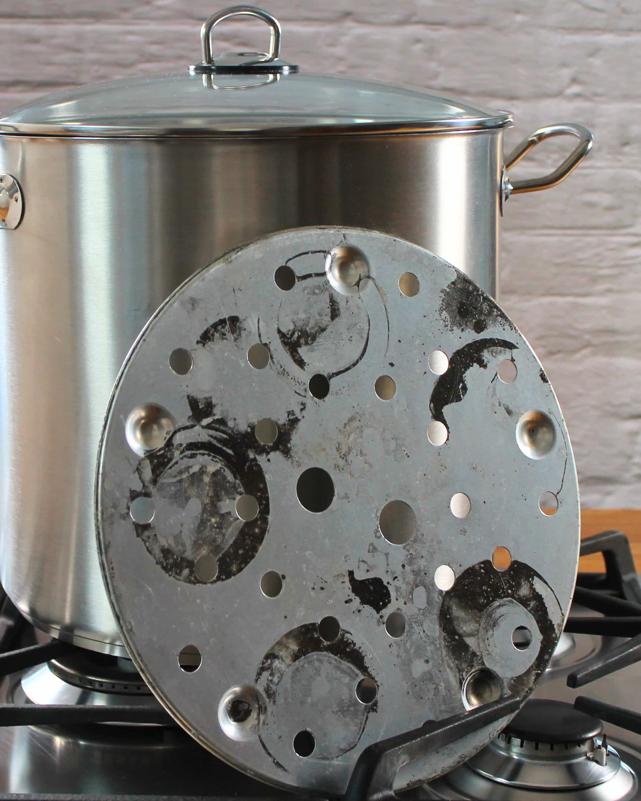 Einkochtopf mit Einsatzplatte auf einem Gasherd, vorbereitet für das Einkochen im Wasserbad