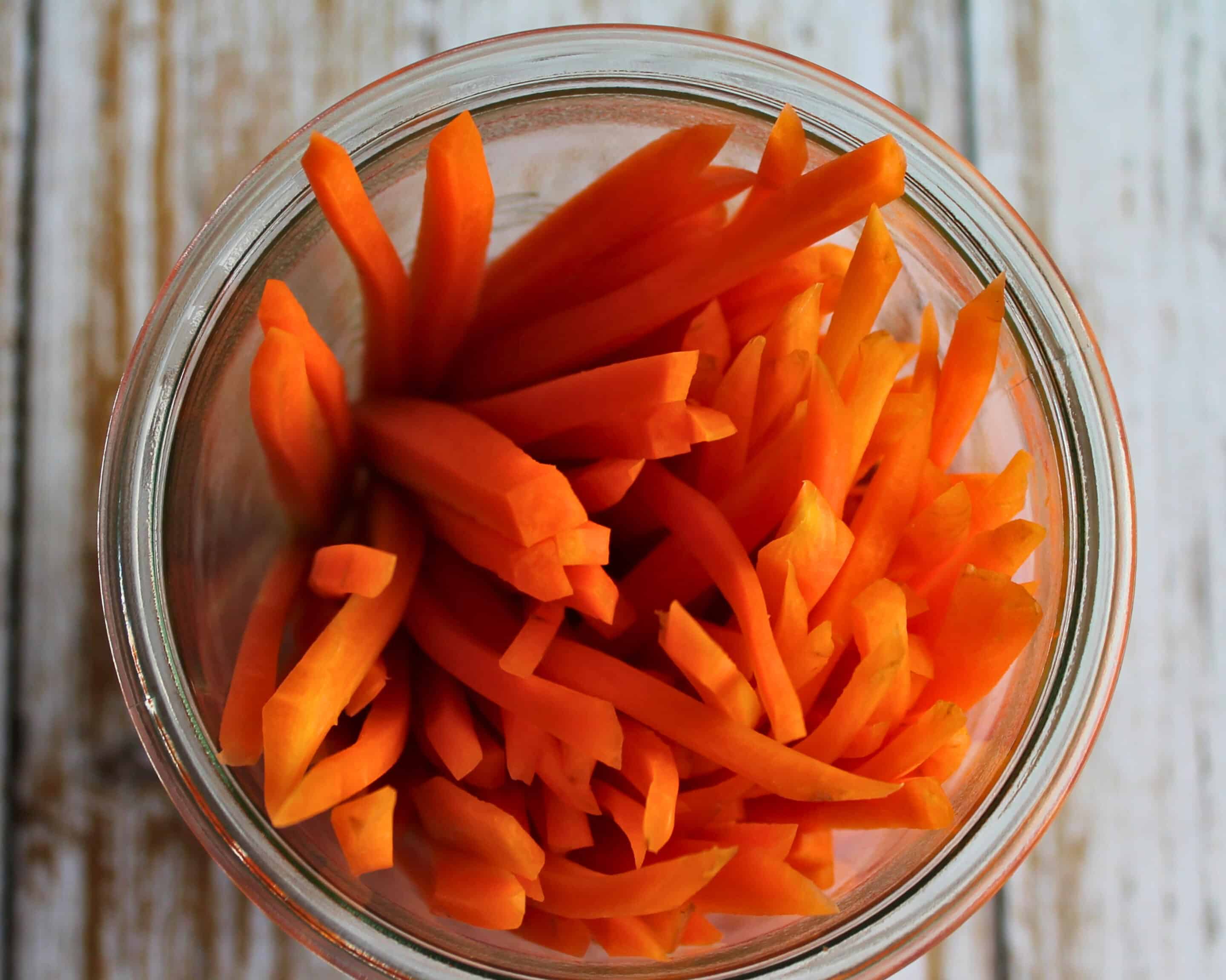 In Streifen geschnittene Karotten im Glas vor dem Fermentieren