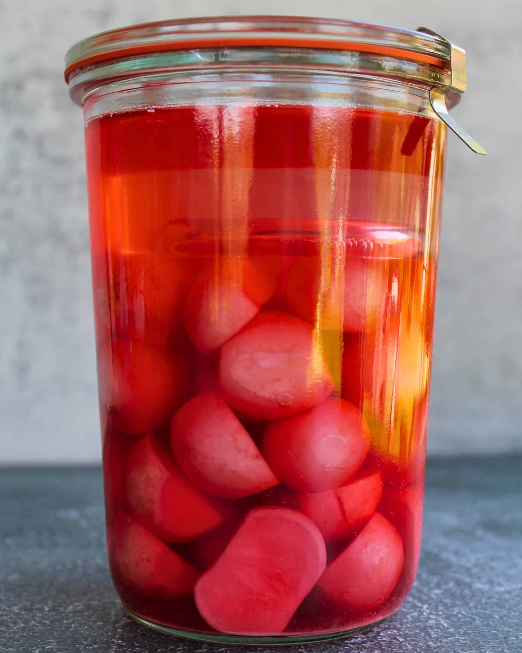 Weckglas mit fermentierten Radieschen in tiefrosa Lake – verschlossen und fertig zum Warten