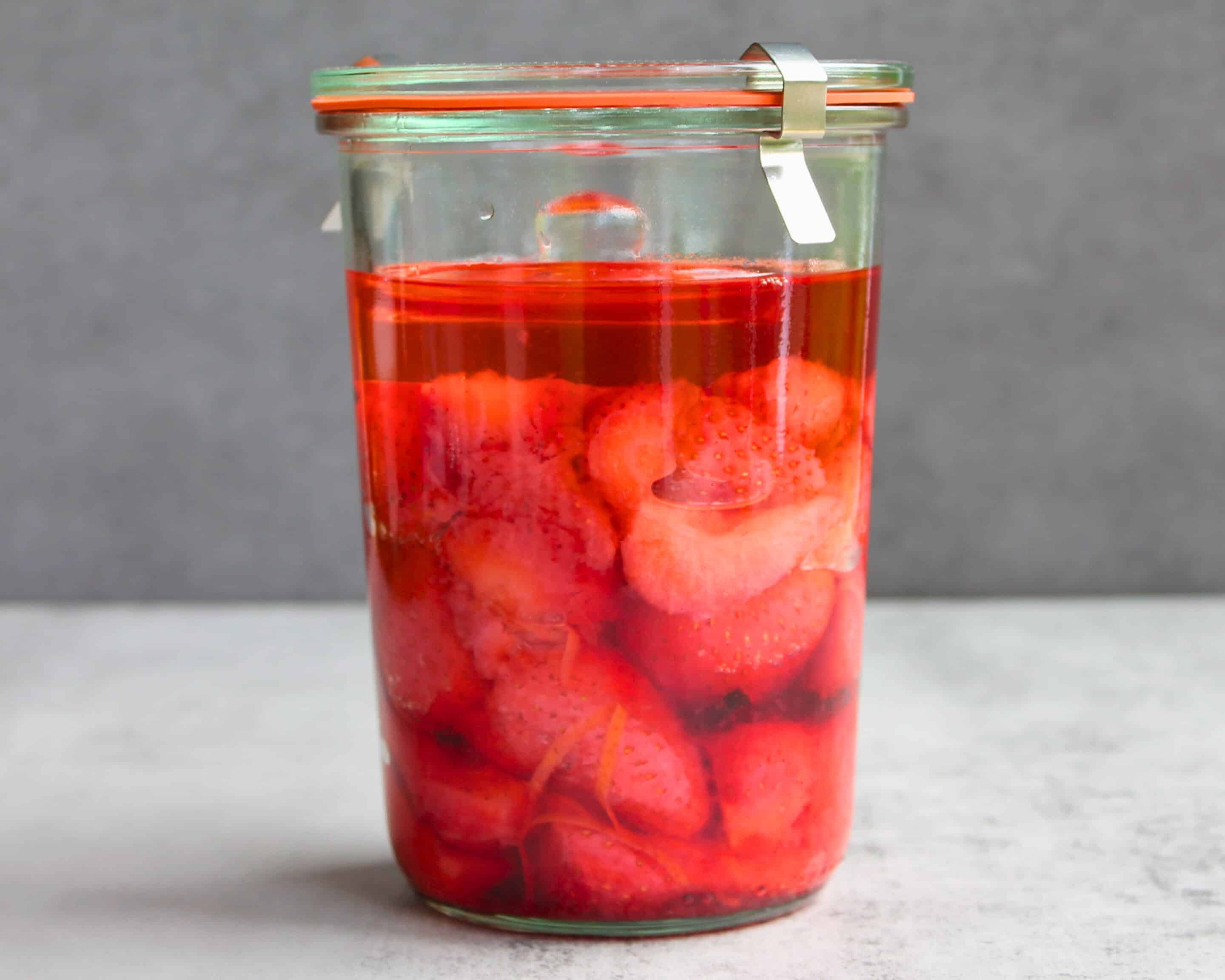 Fermentierte Erdbeeren im Weckglas mit tiefrotem Fruchtsaft nach der Fermentation