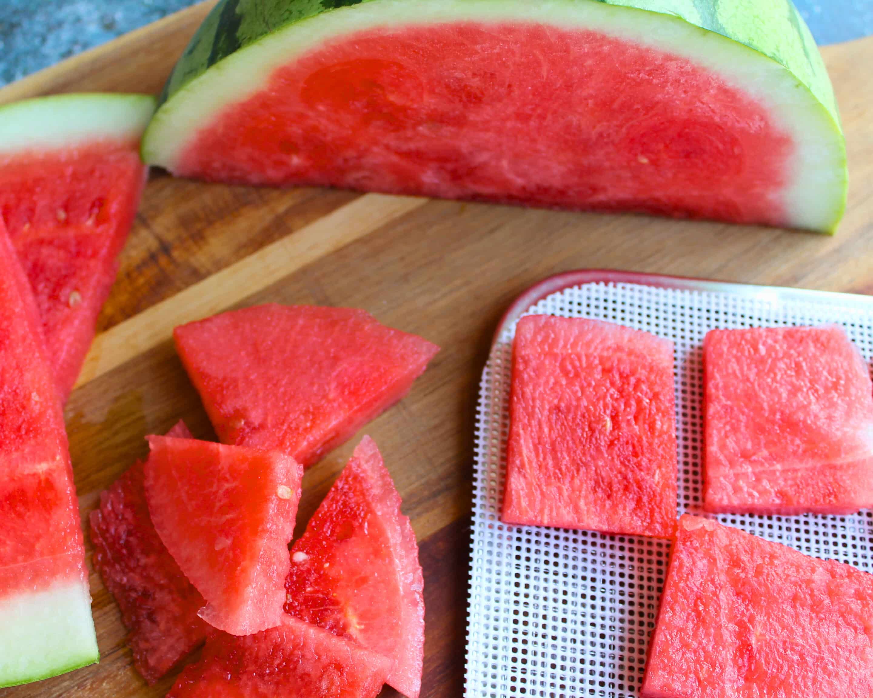 Gleichmäßig geschnittene Wassermelonenscheiben liegen vor dem Dörren auf einem Dörrgitter